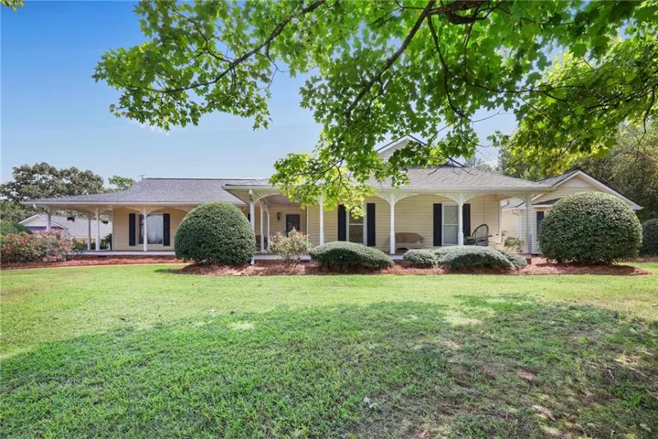 Expansive front lawn with mature trees and established shrubbery