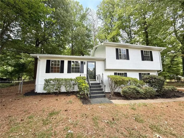 White siding exterior with dark shutters, featuring a multi-level design