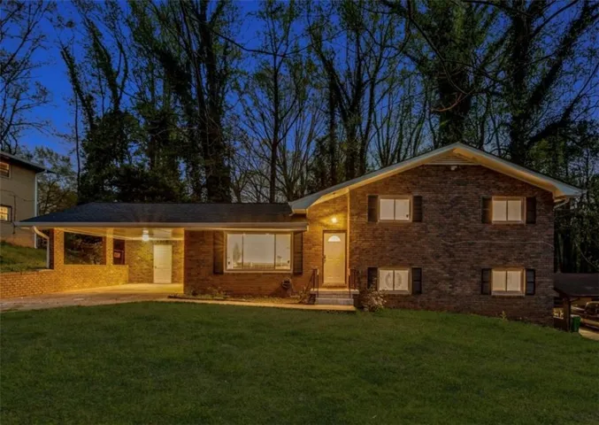 Tri-level home with a carport and a front yard