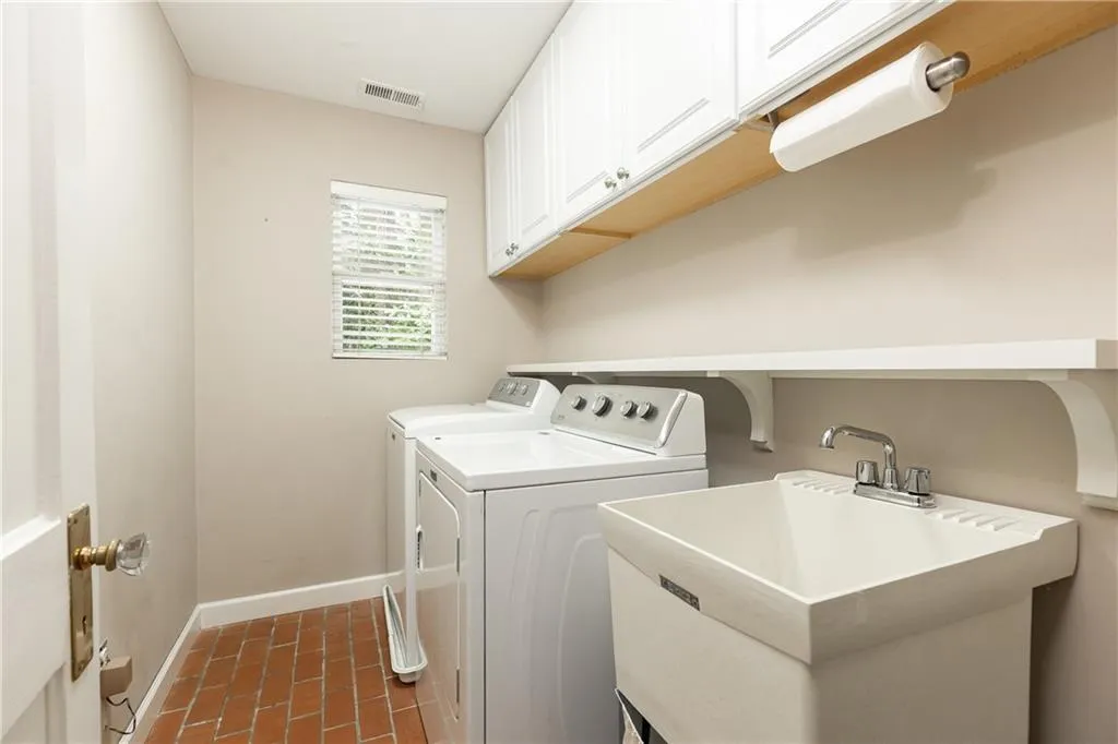 Laundry area with cabinet space and washer and clothes dryer