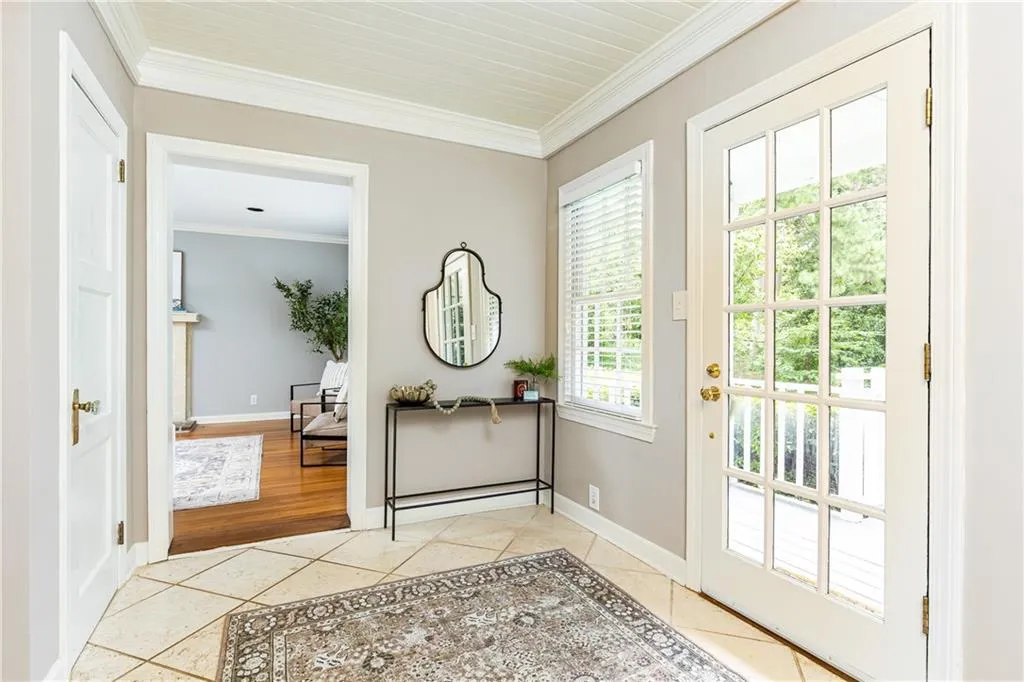 Doorway with crown molding and tile patterned floors