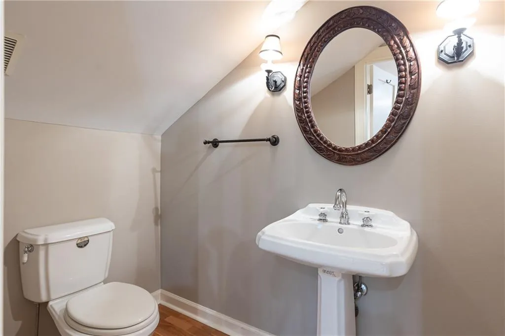 Bathroom with vaulted ceiling and wood finished floors