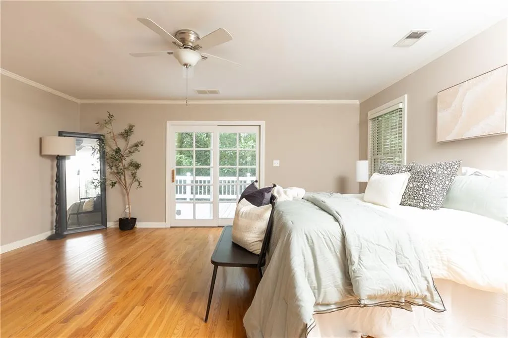 Bedroom with access to outside, light wood finished floors, crown molding, and a ceiling fan