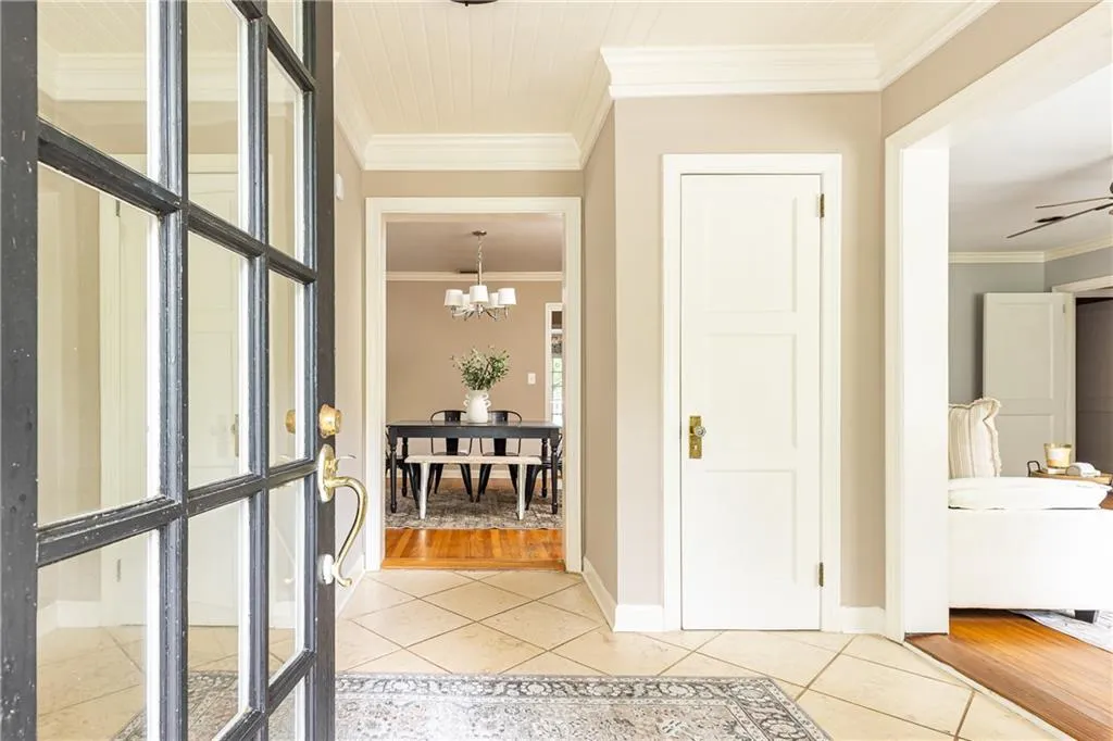 Foyer featuring ornamental molding, light tile patterned floors, and a chandelier