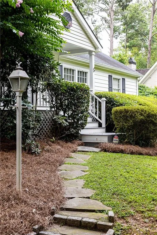 View of exterior entry featuring a chimney and a lawn