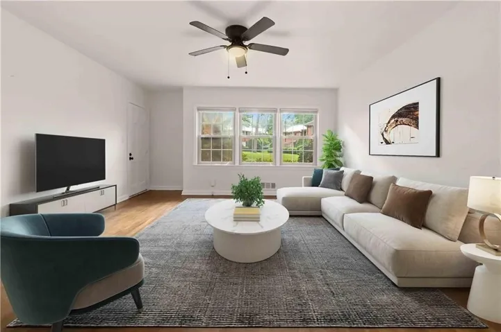 Virtually staged - Living room Hardwood-style flooring, white walls, multi-pane windows, and a ceiling fan with integrated lighting