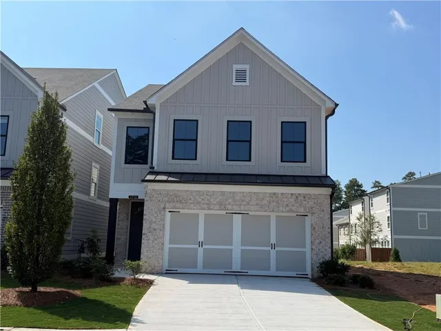 Contemporary facade featuring vertical siding and stone accents