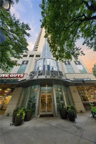 High-rise building with a distinctive glass-front entrance and curved architectural details