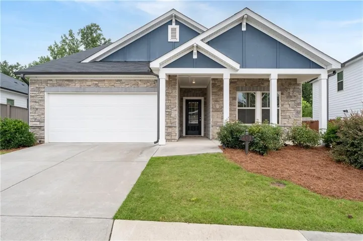 Craftsman-style facade featuring stone veneer and blue siding accents