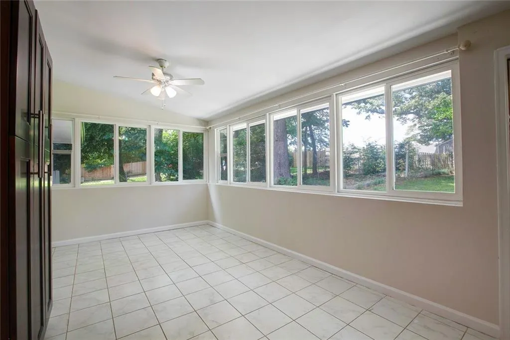 Unfurnished sunroom featuring a healthy amount of sunlight and ceiling fan