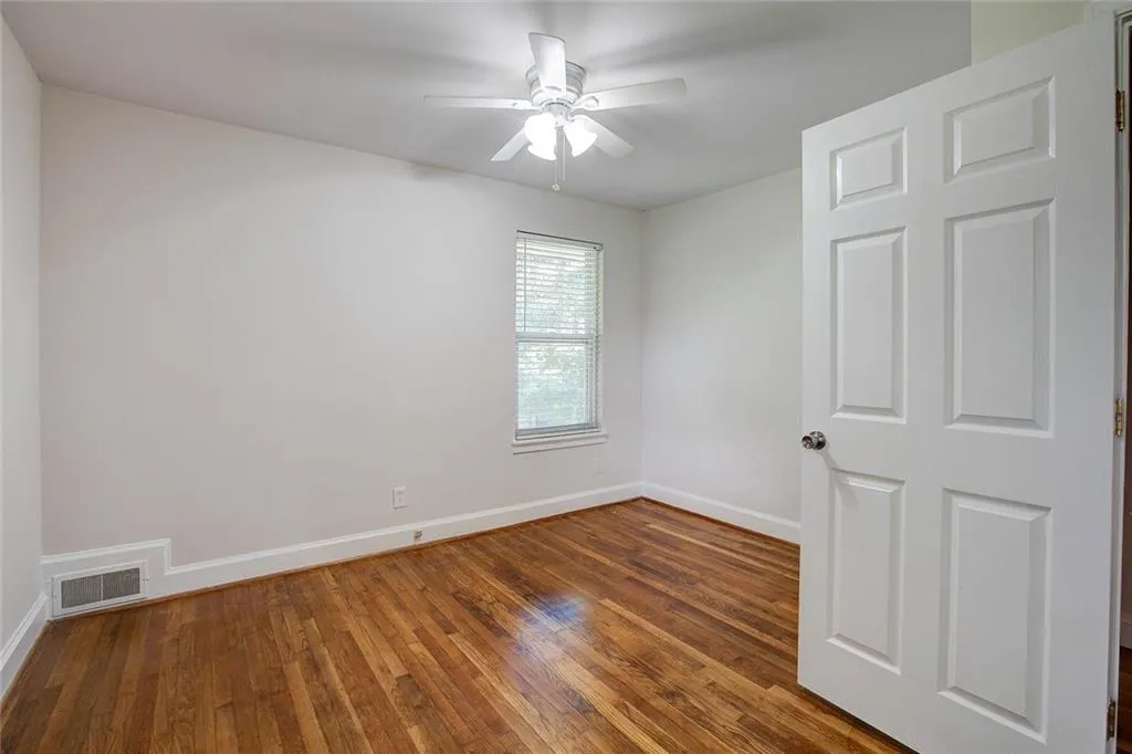 Empty room featuring dark hardwood / wood-style floors and ceiling fan