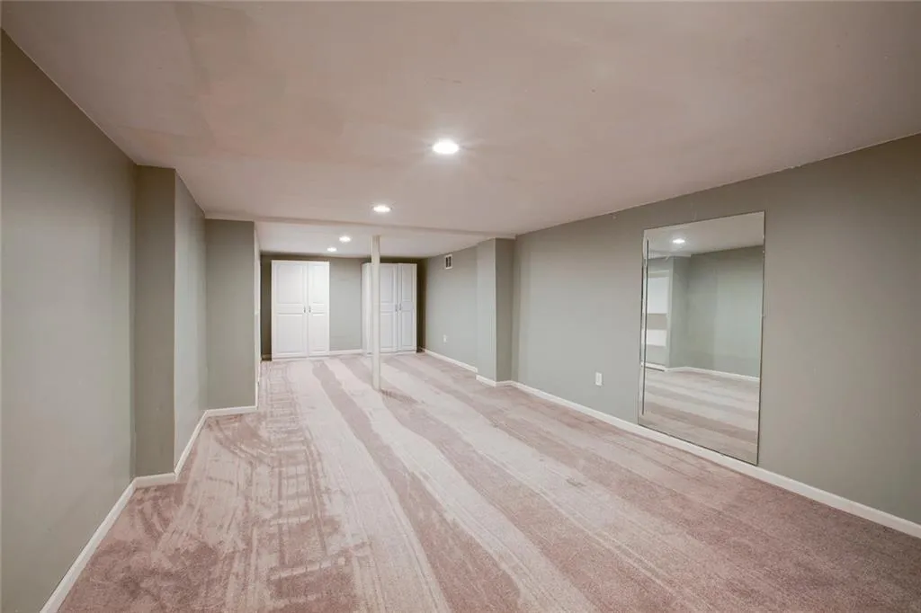 Basement featuring light carpet