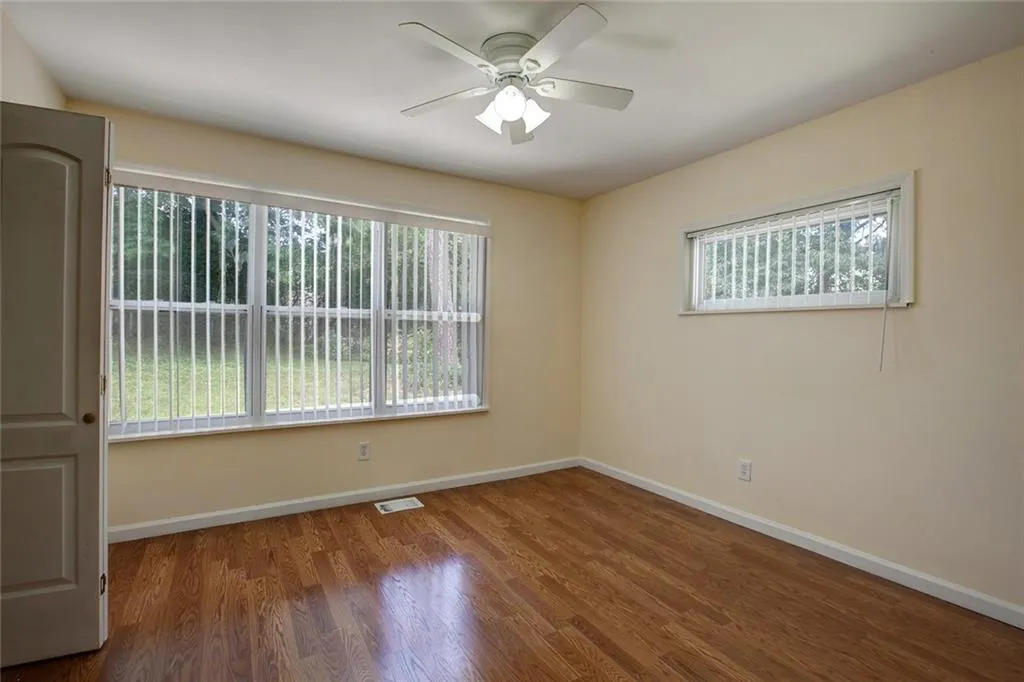Empty room featuring ceiling fan and hardwood / wood-style flooring