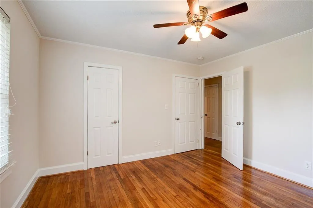 Unfurnished bedroom featuring ornamental molding, ceiling fan, and hardwood / wood-style floors