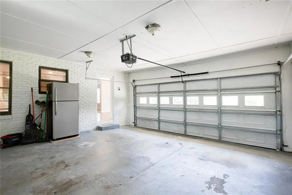 Garage featuring stainless steel fridge and a garage door opener