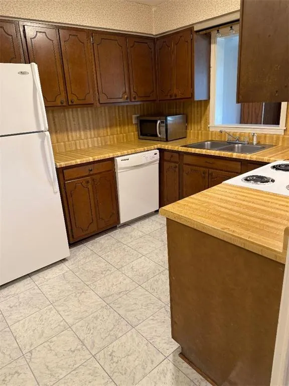 Kitchen featuring light countertops and white appliances