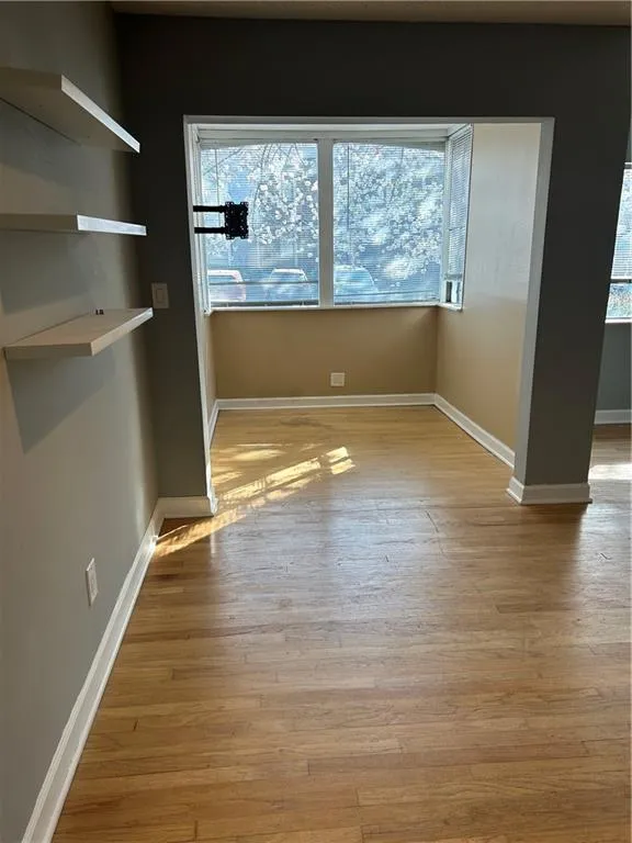 Unfurnished dining area featuring baseboards and light wood finished floors
