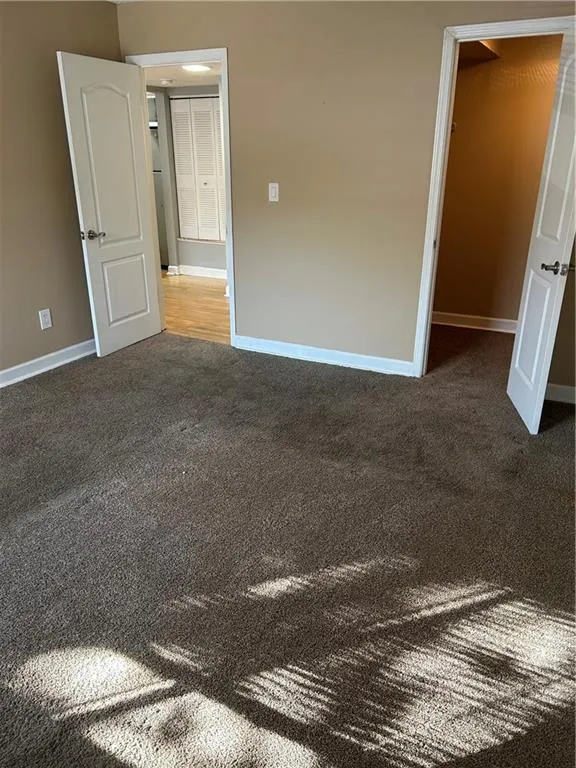 Unfurnished bedroom with a walk in closet and carpet floors