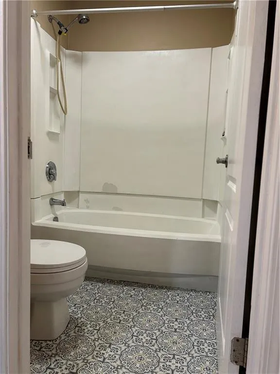Bathroom featuring tub / shower combination and light tile patterned floors