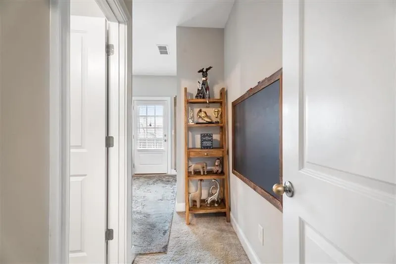 Hallway featuring light colored carpet