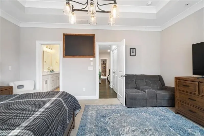 Bedroom featuring crown molding, hardwood / wood-style floors, and a tray ceiling