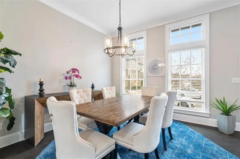 Dining room featuring ornamental molding, a chandelier, and a towering ceiling
