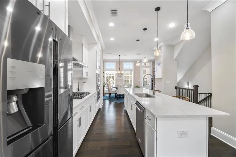 Kitchen with decorative light fixtures, sink, an island with sink, and stainless steel appliances