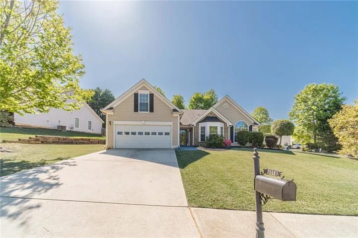 Contemporary single-story residence featuring a two-car garage, bay window, and arched window accent