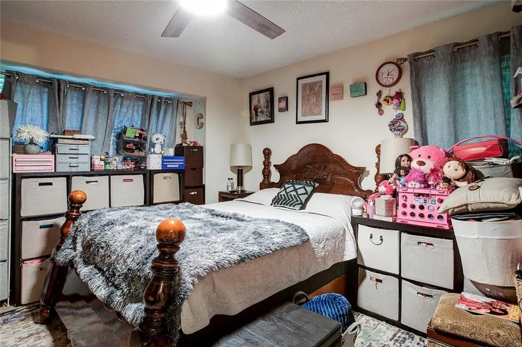 Bedroom featuring ceiling fan and a textured ceiling