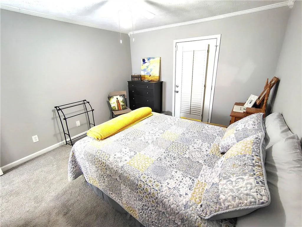 Carpeted bedroom 2 with a closet, baseboards, and ornamental molding