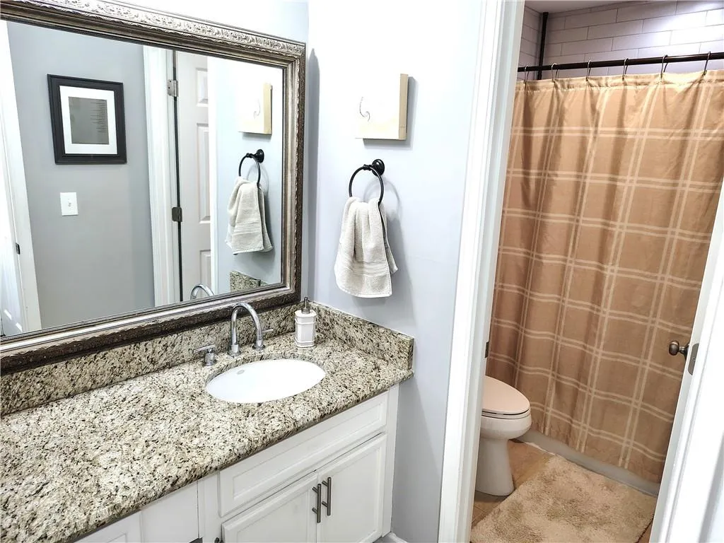 Full bath with tile patterned flooring, toilet, vanity, and a shower with shower curtain