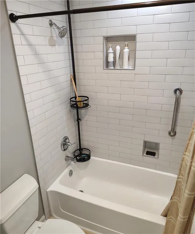 Full bath with toilet and shower / bath combo with shower curtain
