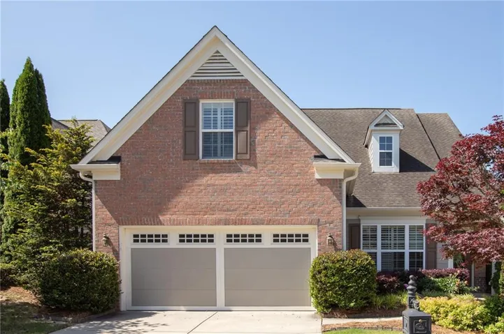 Traditional brick exterior with white trim, featuring a two-car garage with transom windows