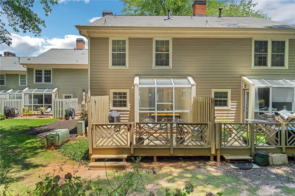Rear view of property featuring cooling unit and a deck