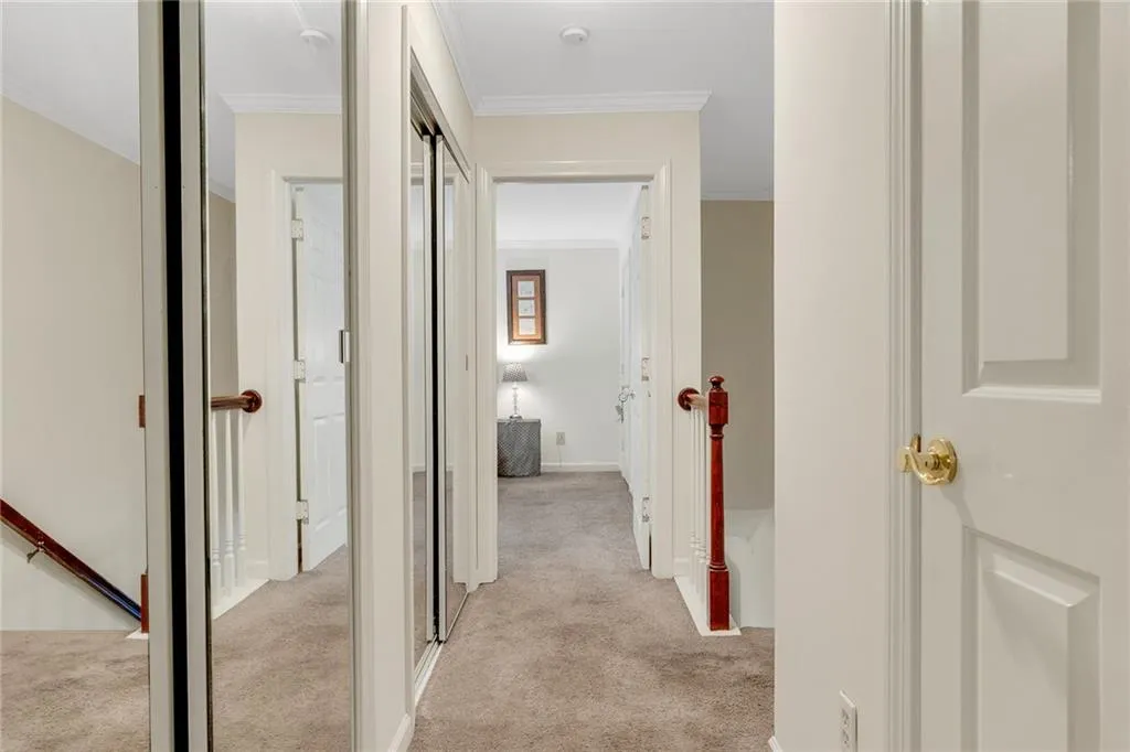 Corridor featuring light carpet and crown molding