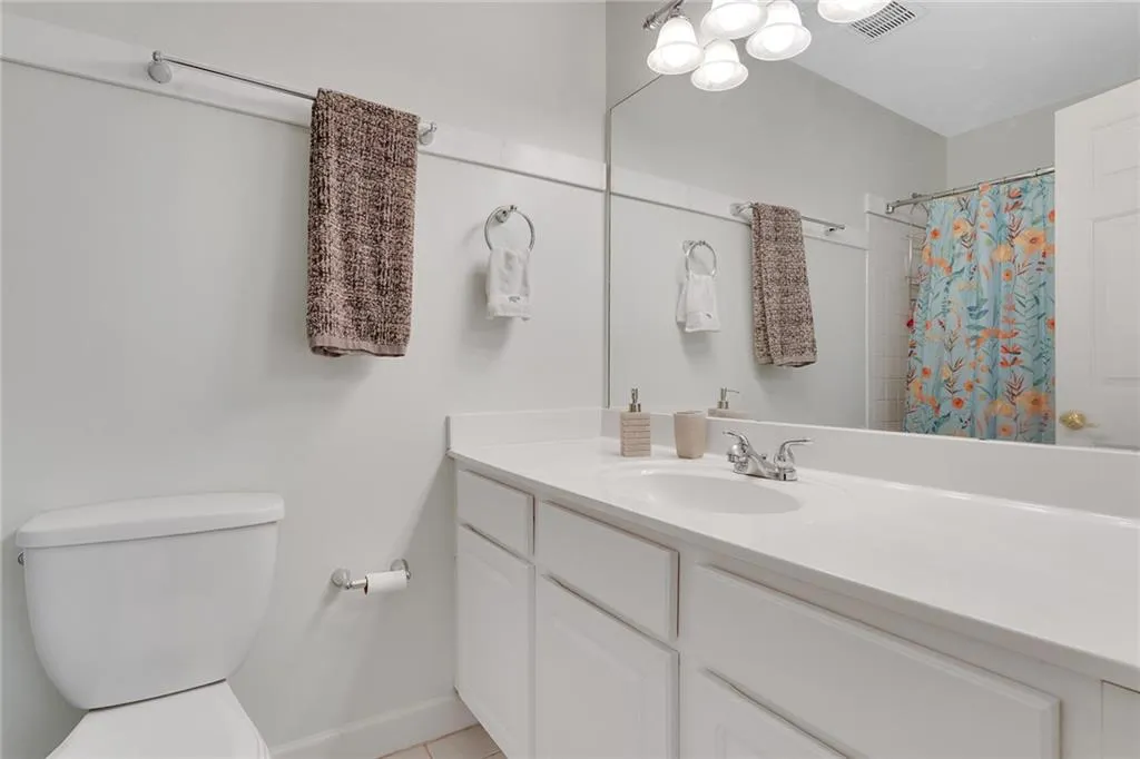 Bathroom featuring tile patterned flooring, toilet, and vanity