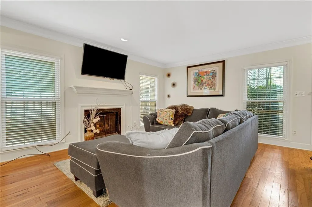 Living room featuring crown molding, a healthy amount of sunlight, and light hardwood / wood-style flooring