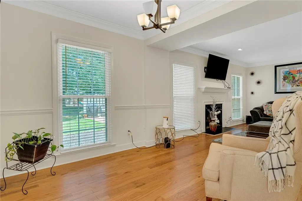 Living room with light hardwood / wood-style floors, a wealth of natural light, and crown molding