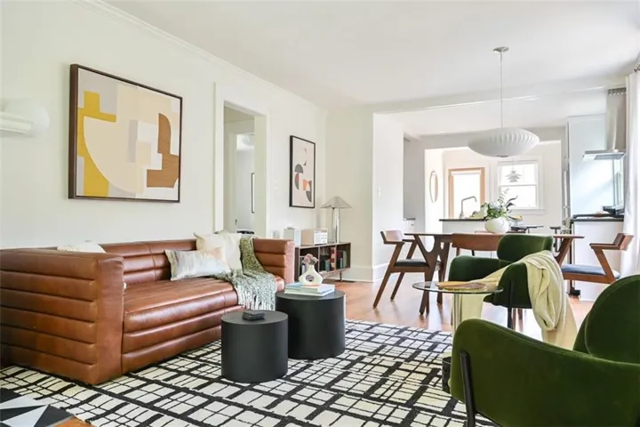 Living area with ornamental molding and light wood-style floors