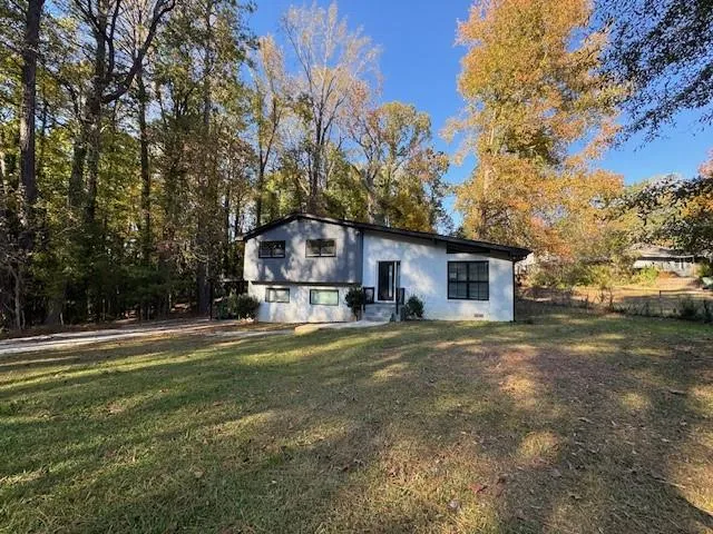 View of front of home with a front lawn and stucco siding