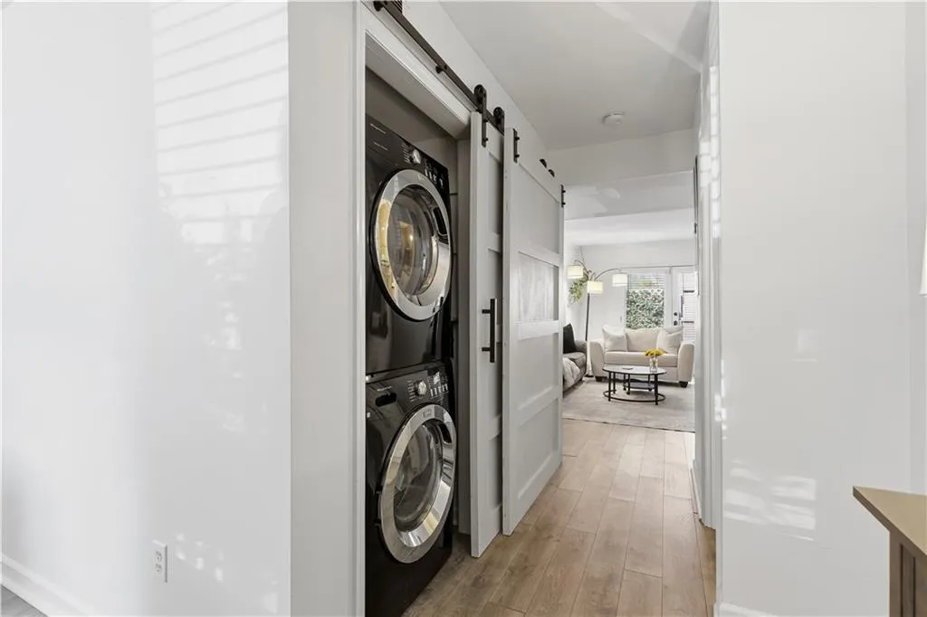 Stackable laundry appliances with barn door enclosure