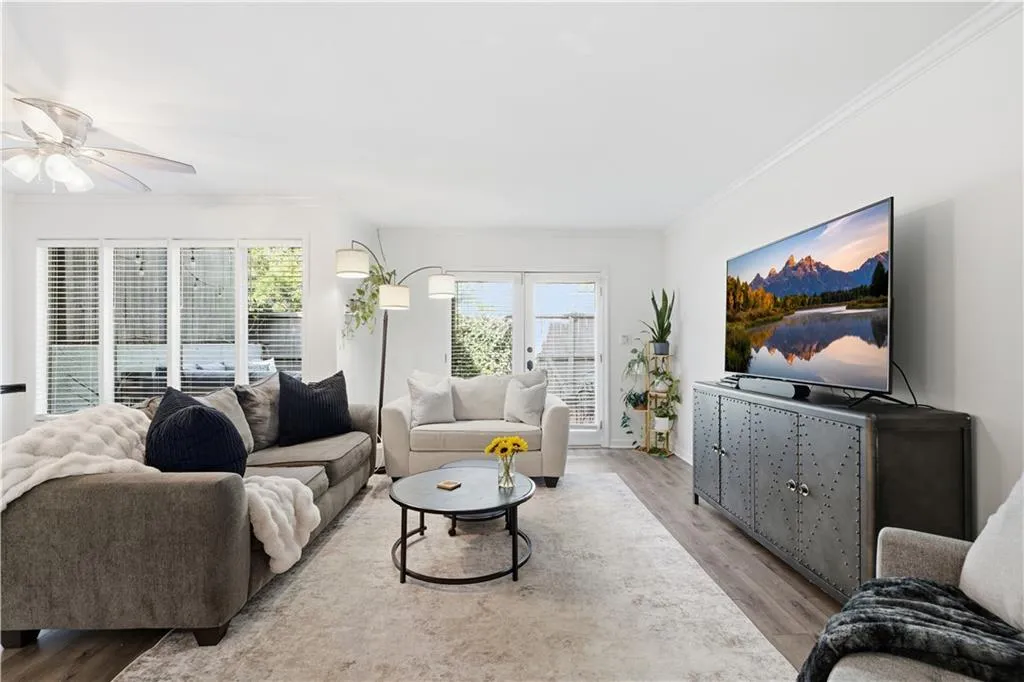 Bright living area featuring wood-finish flooring and white walls