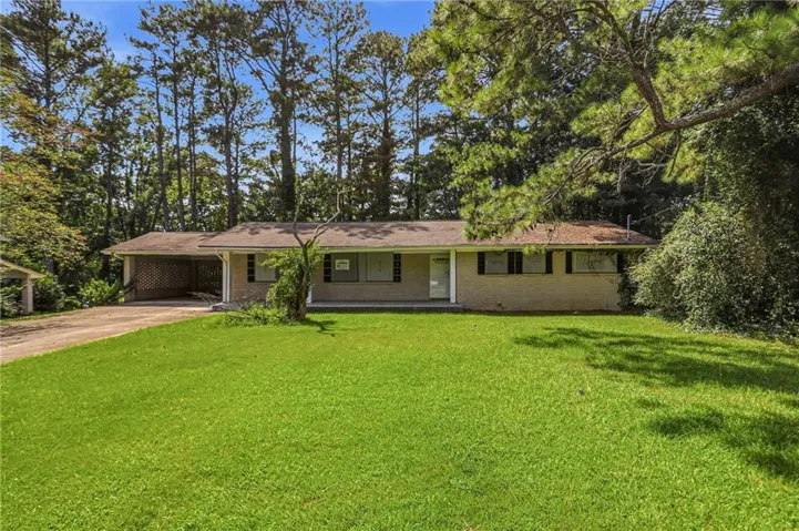 Brick exterior with a covered carport and a paved driveway