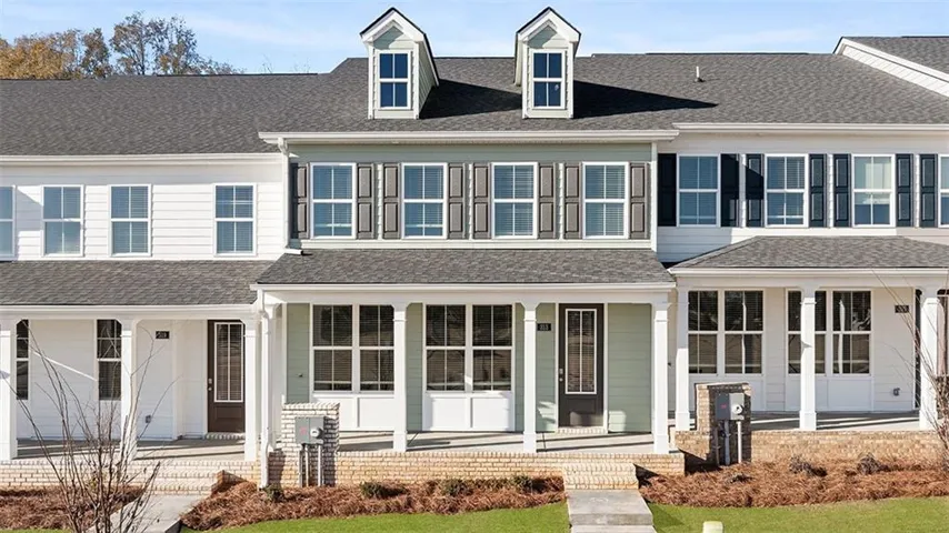 View of front of home with covered porch and roof with shingles