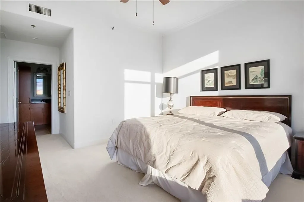 Bedroom featuring visible vents, crown molding, carpet, baseboards, and a ceiling fan