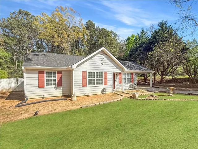 Ranch-style house featuring a shingled roof and a porch