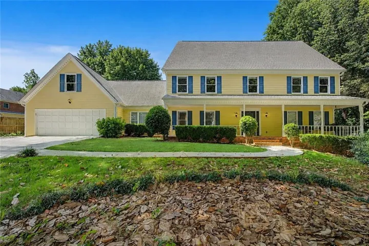 Yellow exterior with a covered front porch featuring white railings