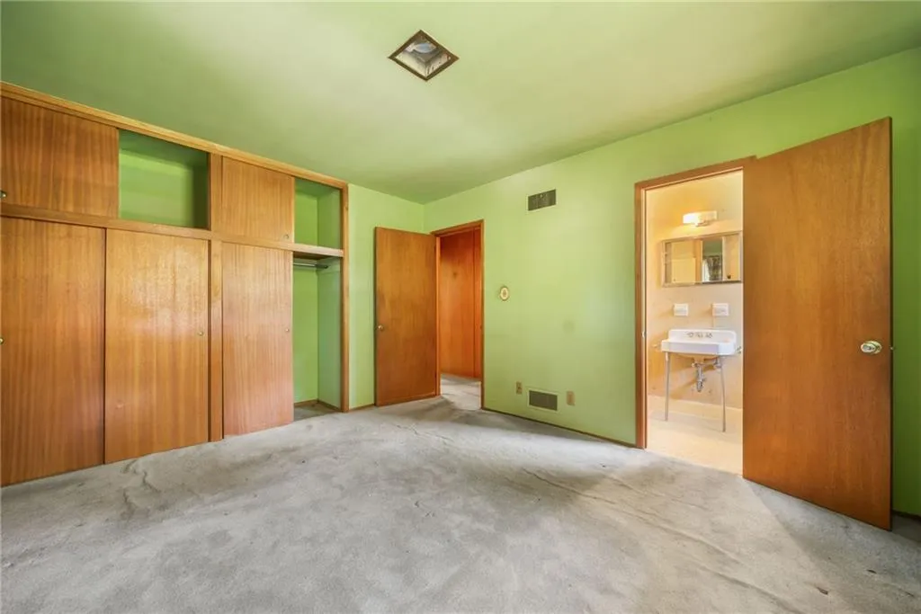 Unfurnished bedroom featuring a closet, carpet flooring, and ensuite bath