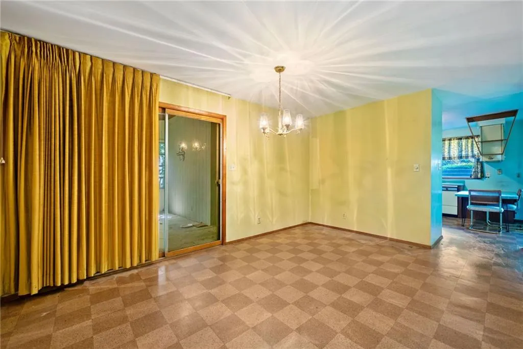 Unfurnished dining area featuring tile patterned floors and a chandelier