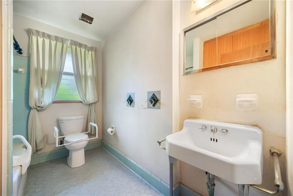Bathroom featuring baseboards and toilet